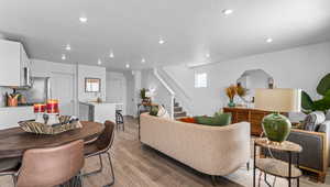 Living room featuring light wood-style flooring, a textured ceiling, and recessed lighting