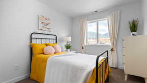 Bedroom with dark carpet, a mountain view, and a textured ceiling