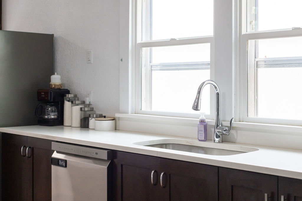 Kitchen featuring dark wood finish cabinets, stainless steel appliances, and light stone counters