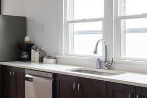 Kitchen featuring dark wood finish cabinets, stainless steel appliances, and light stone counters