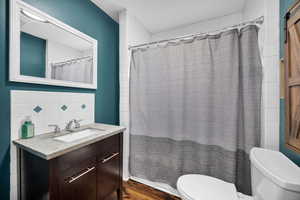 Bathroom featuring vanity, a shower with curtain, and dark wood finished floors