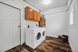 Laundry area with dark wood-style floors, washer and dryer, and cabinet space