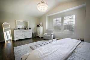 Bedroom with vaulted ceiling,and a chandelier.