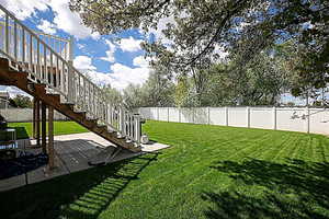 Fenced backyard with stairs and a patio