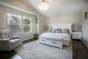 Primary bedroom with LVP flooring and walk in closet.