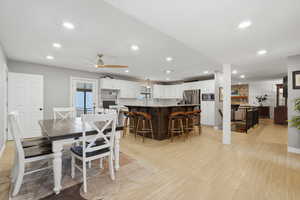Dining room with light wood-style floors, a ceiling fan, and recessed lighting