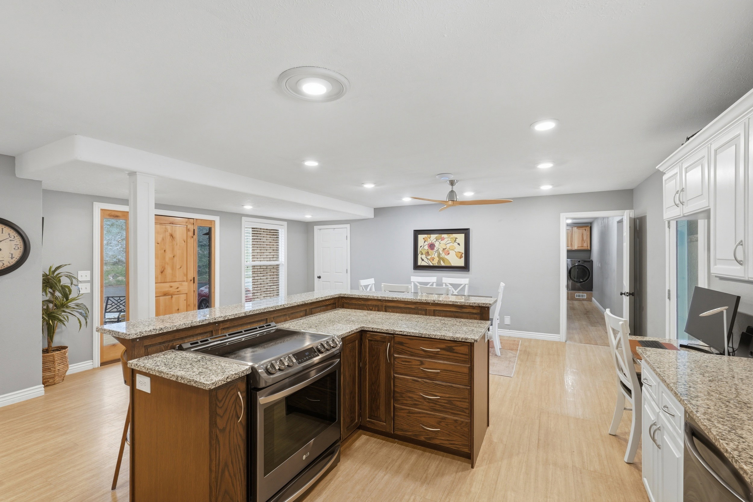 Kitchen featuring granite counters, stainless steel appliances, a kitchen breakfast bar, light wood-style flooring, and recessed lighting