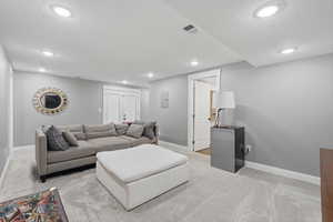 ADU lowr family room with light colored carpet and recessed lighting