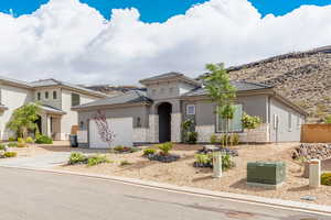 Mediterranean / spanish house with stucco siding, stone siding, concrete driveway, and an attached garage