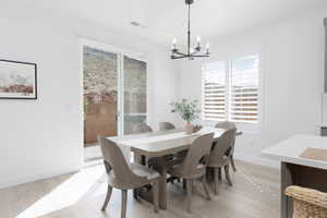 Dining space featuring suspended lighting and light wood-type flooring
