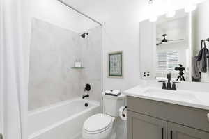 Bathroom with vanity, shower / bath combo, and a ceiling fan
