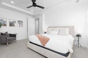 Bedroom with a tray ceiling, light carpet, recessed lighting, and ceiling fan