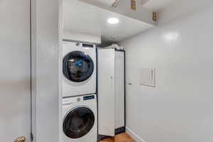 Laundry area featuring stacked washer and clothes dryer and recessed lighting