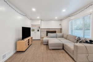 Spacious living room has laminate flooring and a stone fireplace