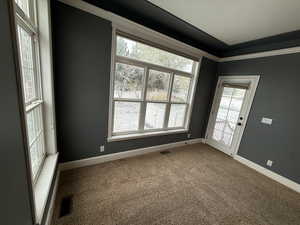 Unfurnished room featuring dark carpet and baseboards