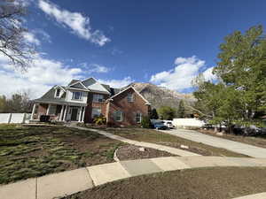 View of front facade with brick siding, covered porch, and a mountain view