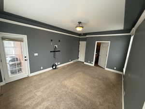 Unfurnished bedroom featuring carpet floors, crown molding, and a spacious closet