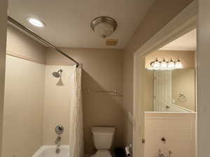 Bathroom featuring shower / bath combination with curtain and recessed lighting