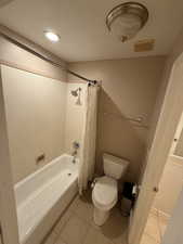 Bathroom featuring shower / tub combo and light tile patterned flooring