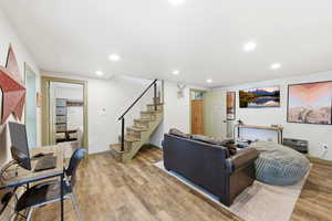 Downstairs living room with french doors, LVP floors, sleeping nook, wood or coal burning stove and recessed lighting
