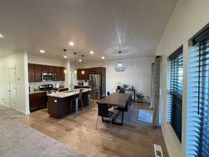 Dining area with light wood-type flooring and recessed lighting
