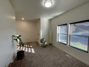 Unfurnished room featuring baseboards and light carpet