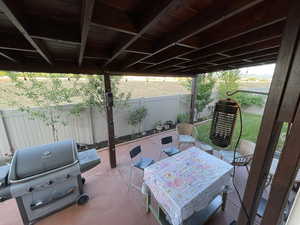 Fenced backyard featuring grilling area, a patio, and outdoor dining space