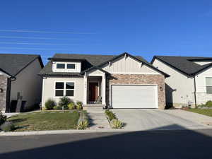 View of front of home with a garage, board and batten siding, concrete driveway, roof with shingles, and a front yard