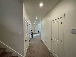 Hallway featuring recessed lighting and dark carpet
