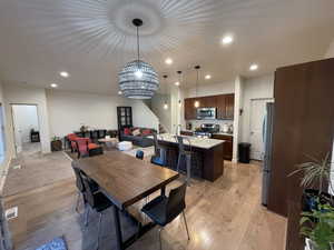 Dining area featuring light wood-type flooring and a chandelier