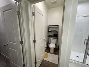 Bathroom with a stall shower and dark wood-style flooring