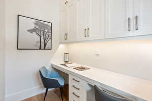 Office featuring built in study area and wood finished floors