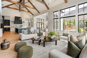 Living area featuring light wood-style flooring, vaulted ceiling, and suspended lighting