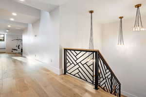 Stairway with hardwood / wood-style flooring and recessed lighting