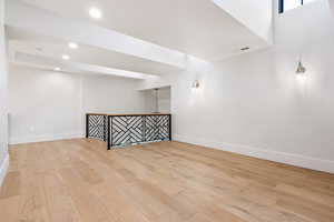 Empty room featuring light wood-style floors, a dry bar, and recessed lighting
