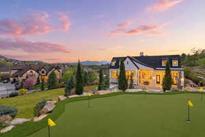 Back of property featuring a chimney, a putting area, and a patio