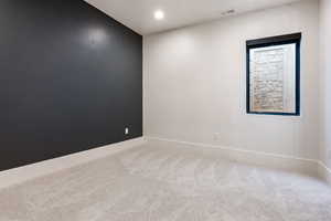 Empty room with recessed lighting and light carpet