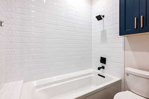 Full bath featuring toilet and washtub / shower combination
