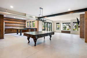 Rec room with recessed lighting and brick wall