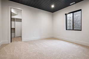 Spare room featuring wooden ceiling, light colored carpet, and recessed lighting