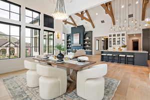 Dining space with a chandelier, light wood finished floors, and vaulted ceiling