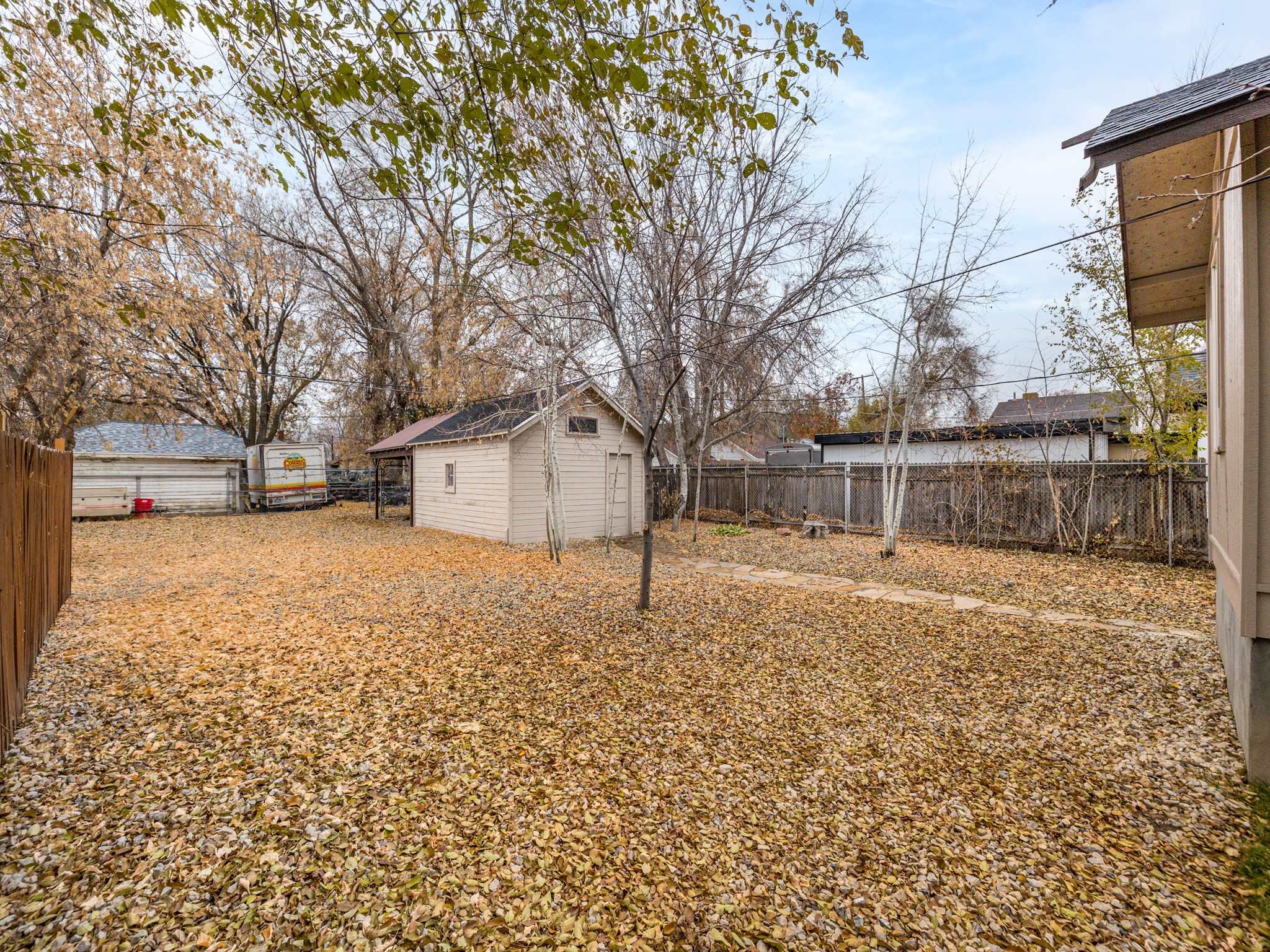 Fenced backyard featuring an outbuilding