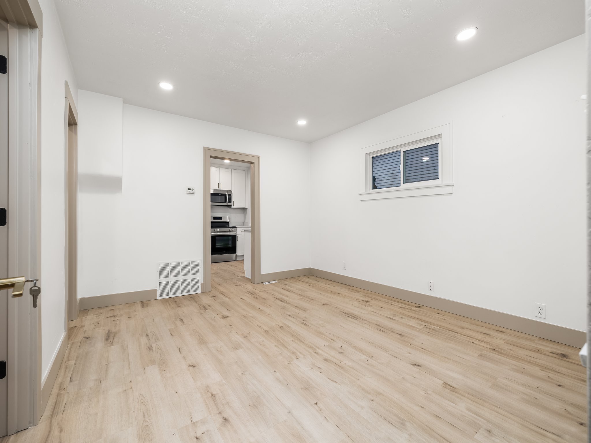 Empty room with light wood finished floors and recessed lighting