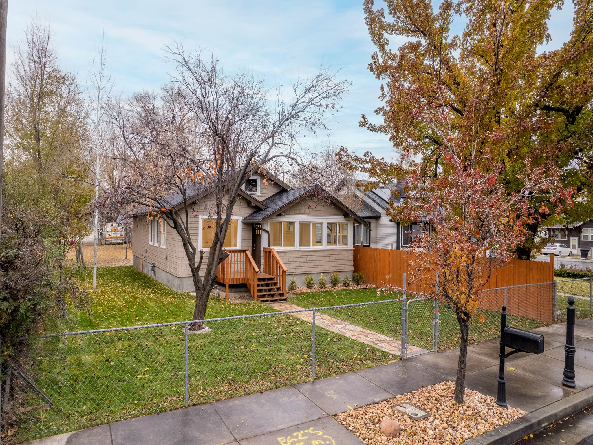 Bungalow with a fenced front yard and a gate