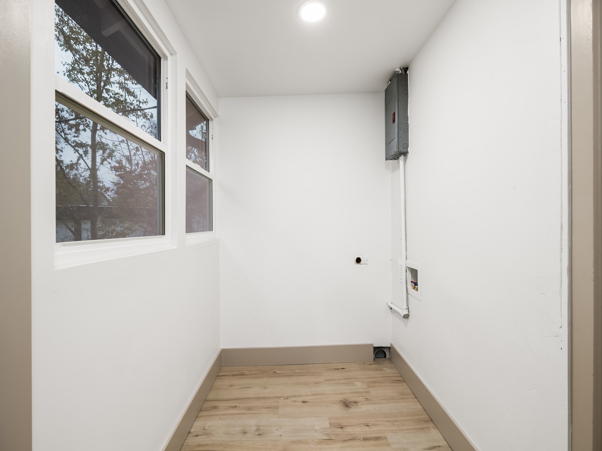 Laundry room with light wood finished floors, washer hookup, hookup for an electric dryer, electric panel, and recessed lighting