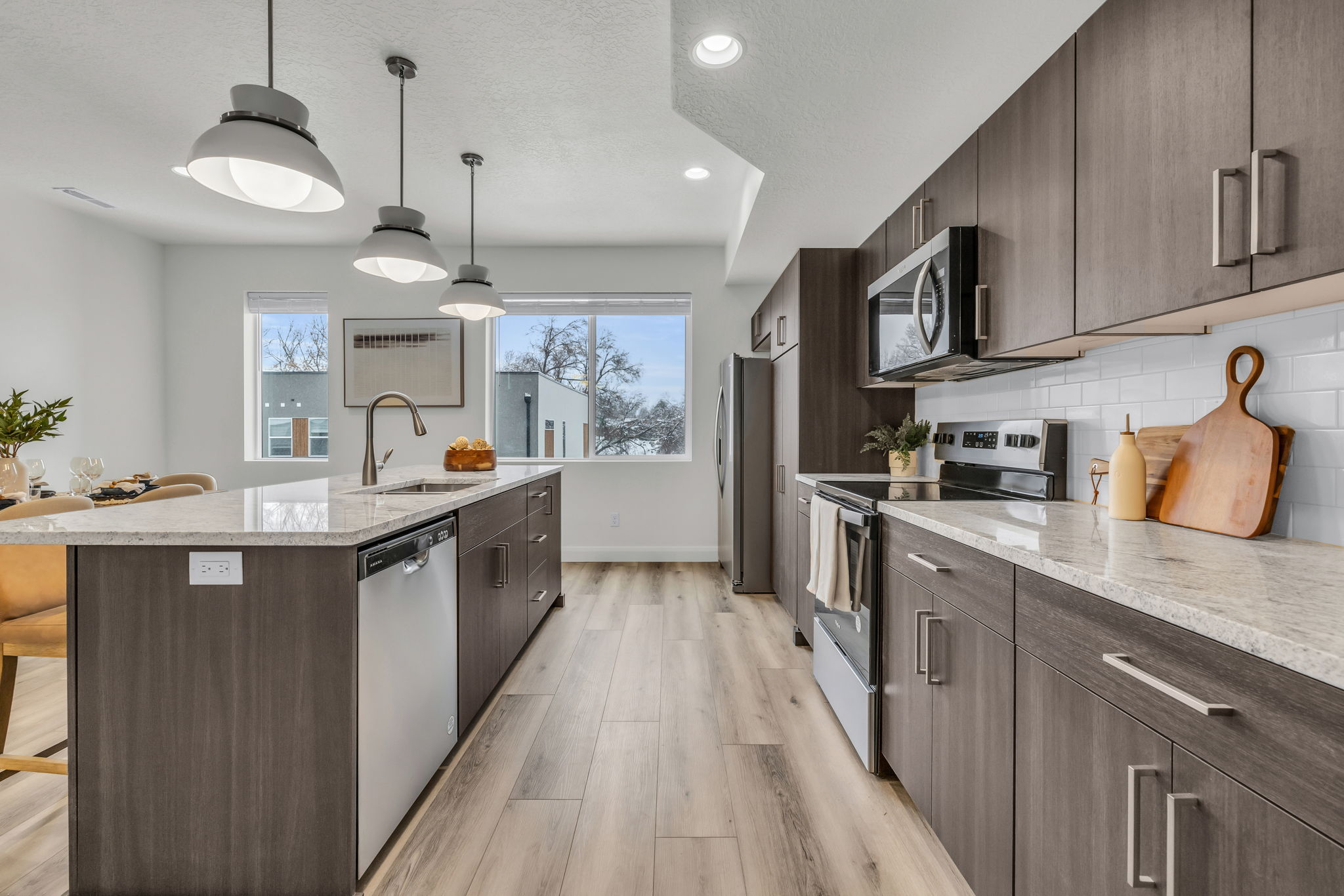 Kitchen with dark wood finish cabinetry, stainless steel appliances, a breakfast bar area, and light stone countertops