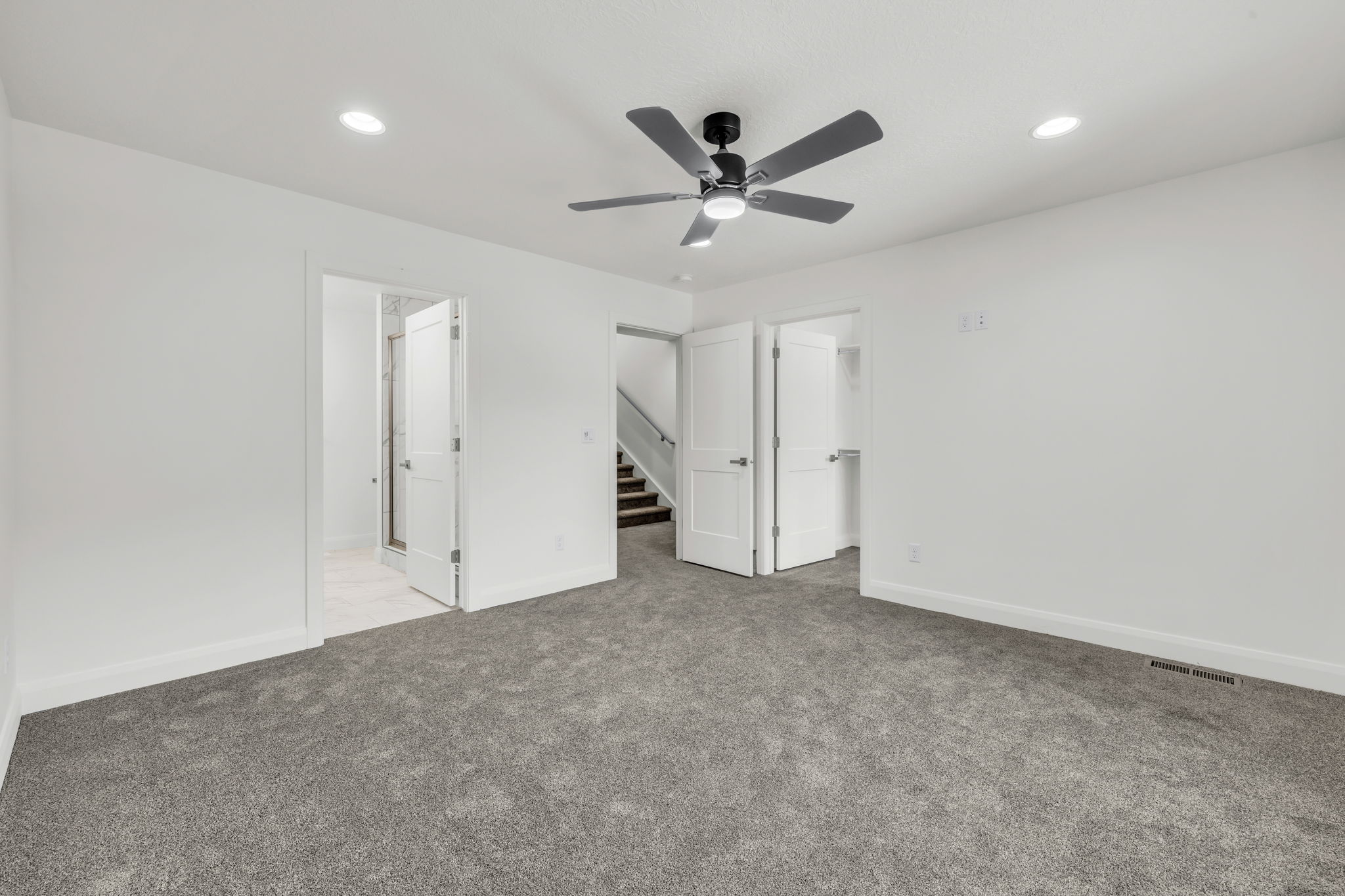 Unfurnished bedroom featuring carpet, a ceiling fan, a spacious closet, and recessed lighting