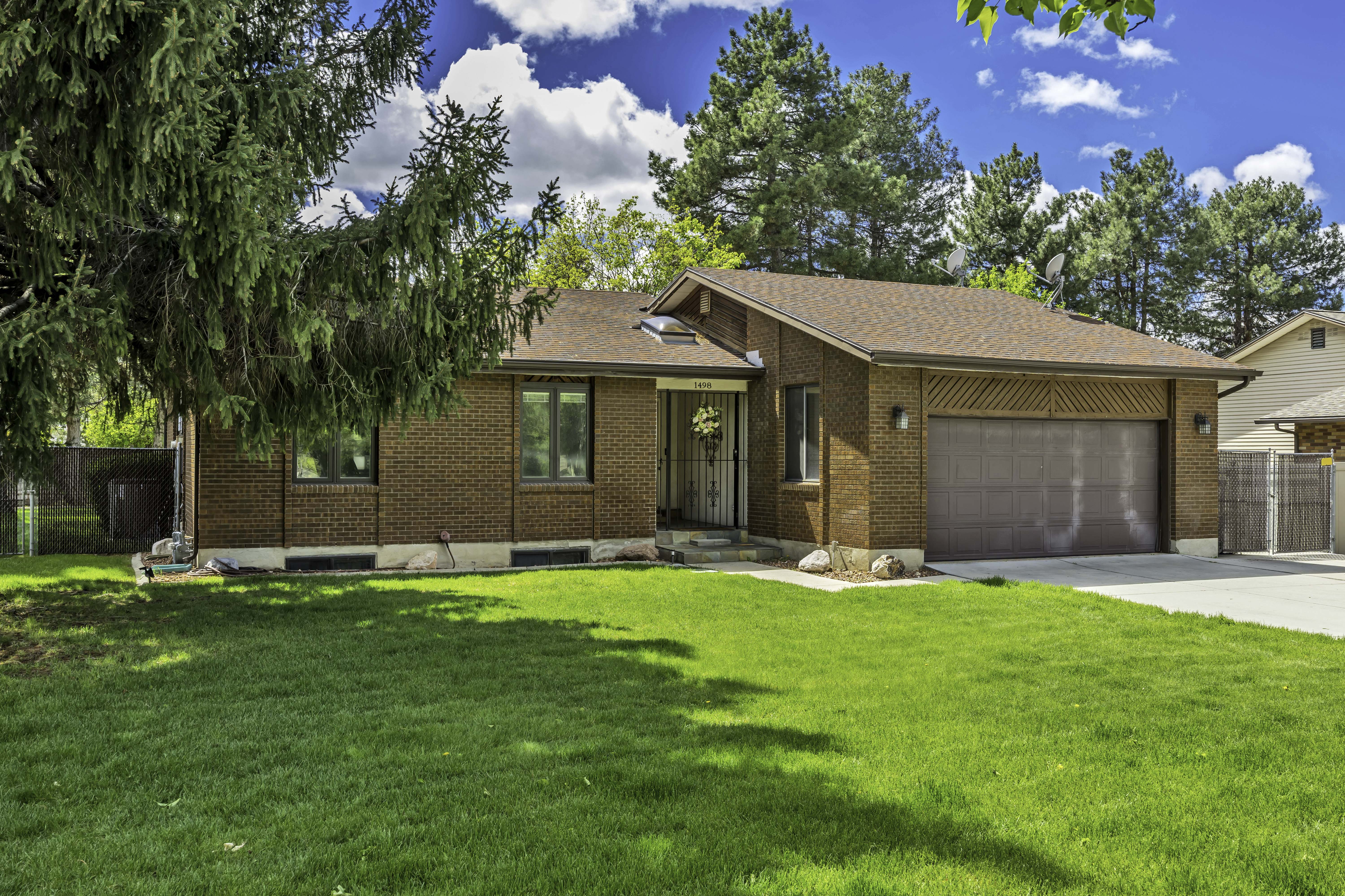 Ranch-style home with brick siding, a garage, a shingled roof, and driveway