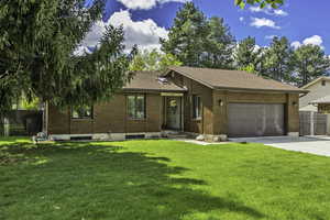 Ranch-style home with brick siding, a garage, a shingled roof, and driveway
