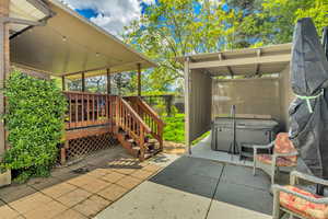 Fenced backyard featuring a patio, a hot tub, and a deck